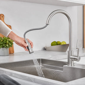Pessoa utilizando a ducha extensível da Torneira Sienne sobre a cuba da cozinha